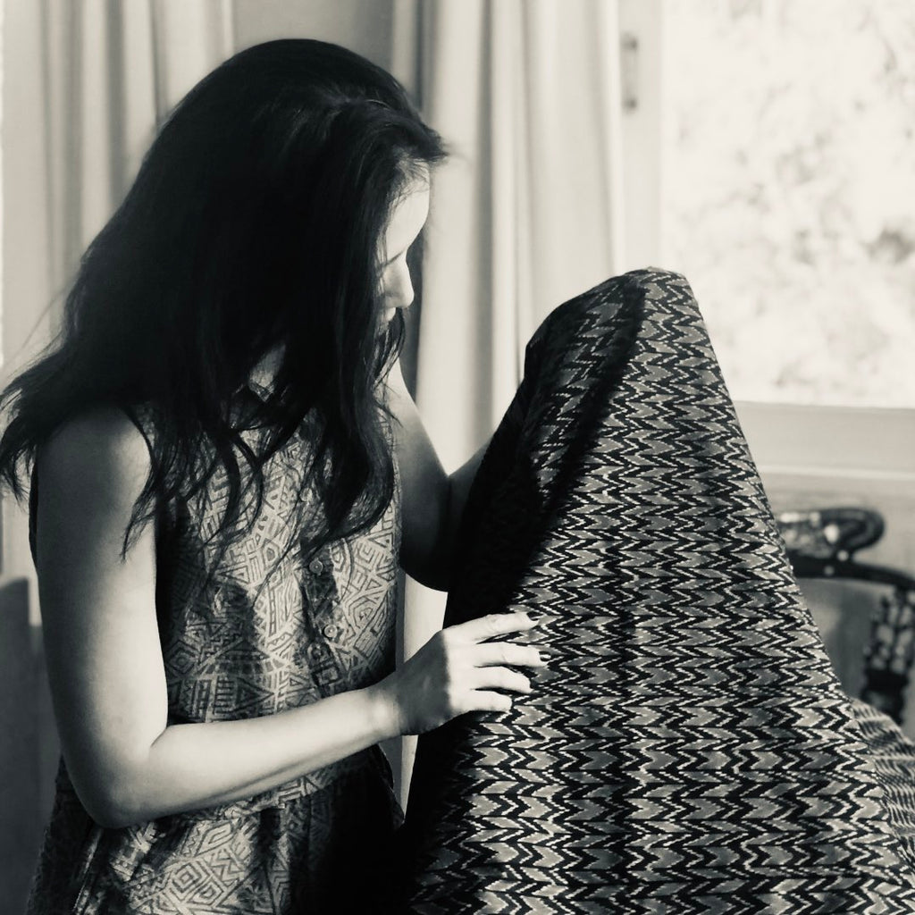 Pring, designer of Sucette artisanal shoes and fashion holding up her textile creation, a contemporary take on traditional mudmee ikat Thai silk